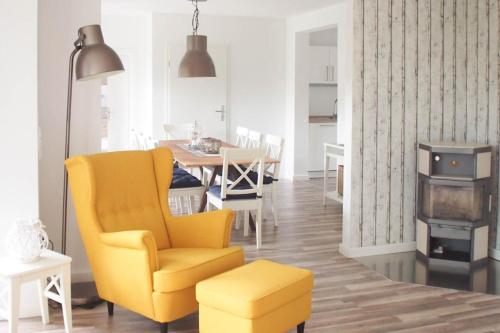 a living room with a yellow chair and a table at Bootshaus in Timmendorfer Strand