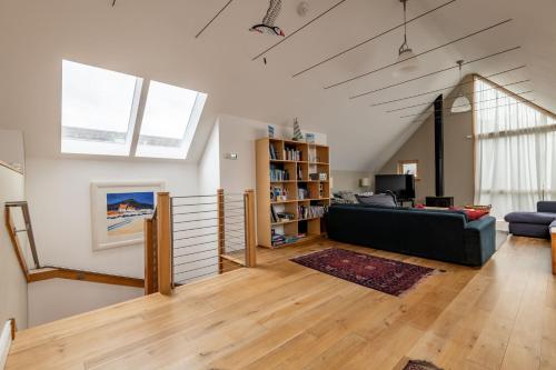 a living room with a couch and a book shelf at Juniper Cottage - Elie in Elie