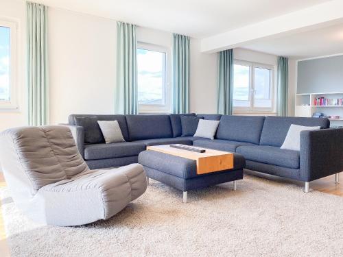 a living room with a blue couch and a chair at Loft in Timmendorfer Strand