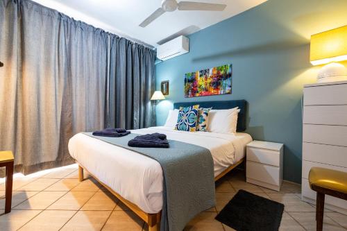 a bedroom with a bed and a blue wall at GhadiraBay seafront with sea views by Homely in Mellieħa