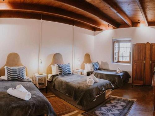 a room with three beds and a couch at Vleidam Guest Farm in Koringberg