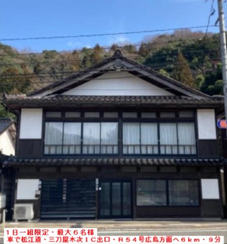 an asian house with black and white windows at 福のや in Unnan