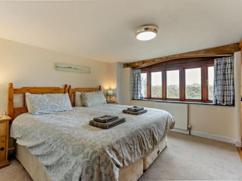 a bedroom with a large bed and a large window at 4 Bed in Bude oc-corys in Morwenstow