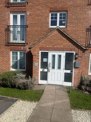a brick house with a white door and windows at Private Room in a shared flat with own Bathroom and Parking in West Bromwich