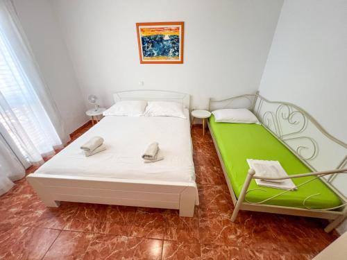 a bedroom with two beds and a green mattress at Robinson Apollon in Gdinj