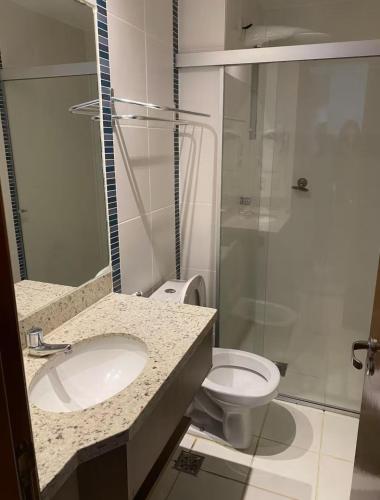 a bathroom with a toilet and a sink and a shower at Flat veredas 300 metros HOT PARK com ar na sala in Rio Quente