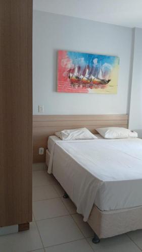 a bedroom with a bed and a painting on the wall at Flat veredas 300 metros HOT PARK com ar na sala in Rio Quente