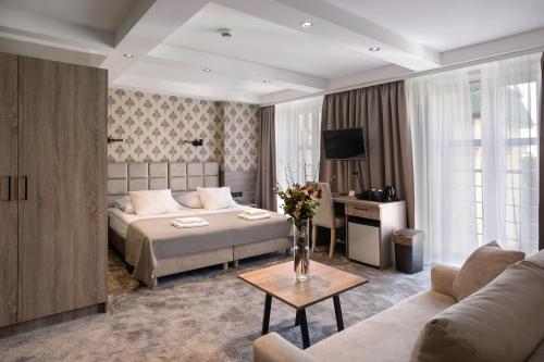 a hotel room with a bed and a couch at Hotel Maksymilian in Krakow
