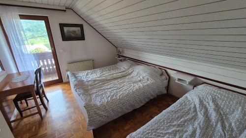a attic room with two beds and a desk at Počitniška hiša Novak in Bohinj