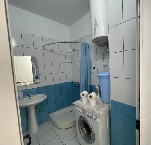 a bathroom with a washing machine and a sink at Beach Home Retreat in Durrës