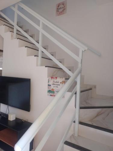 a white staircase with a flat screen tv at Terramar condominium! Coral beach! in Tamoios