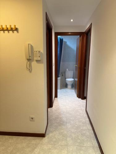 a hallway to a bathroom with a toilet and a phone at Mont-Roig Del Camp in Tarragona