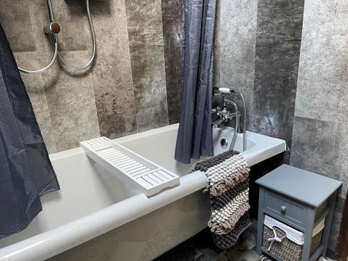 a bathroom with a bath tub with a shower and a sink at 2 Bed in Bodmin oc-90216 in Bodmin