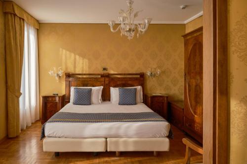 a bedroom with a large bed with a chandelier at Hotel Pensione Wildner in Venice