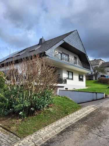 a white house with a black roof at Ferienwohnung Marx in Konz
