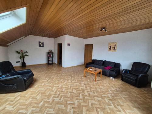 a living room with two couches and a wooden ceiling at Ferienwohnung Marx in Konz