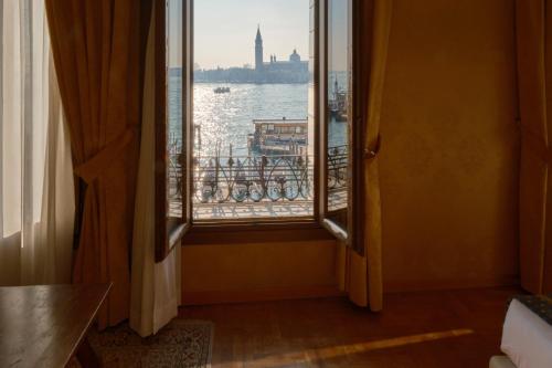 a room with a window with a view of the water at Hotel Pensione Wildner in Venice
