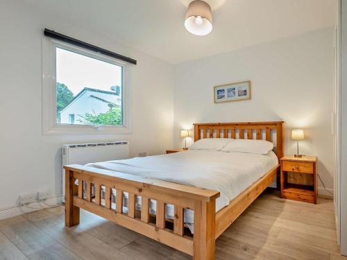 a bedroom with a large wooden bed and a window at 3 Bed in Saltash oc-30040 in Wotter