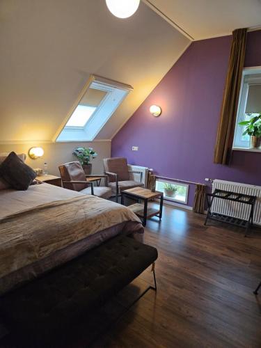 a bedroom with a large bed and purple walls at Veenemaat B&B in Winterswijk