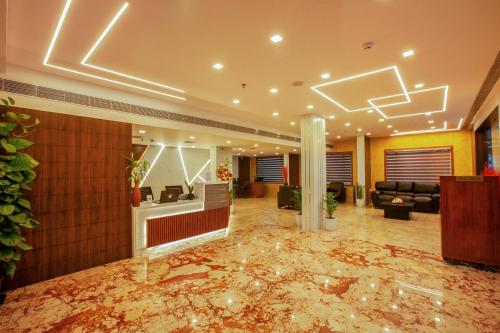 a large lobby with a marble floor and a lobby at Hotel Laals Inn Grand in Cochin