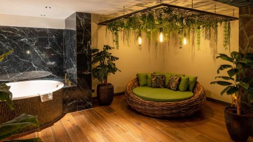 a bathroom with a tub and a chair and a sink at Van der Valk Hotel Assen in Assen