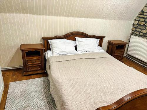 a bedroom with a bed with two night stands and two tables at Voineasamountainvillas in Voineasa