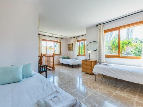 a bedroom with two beds and a large window at Sa casa des Padrino in Santa Ponsa