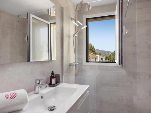 a white bathroom with a sink and a window at Sa casa des Padrino in Santa Ponsa