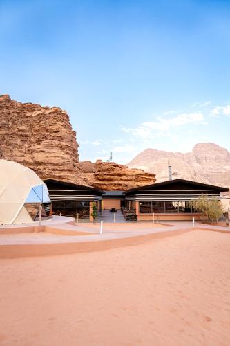 Ein Gebäude in der Wüste mit Bergen im Hintergrund in der Unterkunft Terra Nova Camp in Wadi Rum
