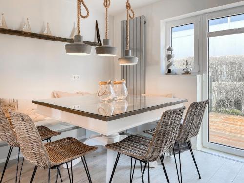 a dining room with a white table and chairs at Strandbude in Timmendorfer Strand