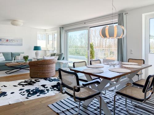 a living room with a dining room table and chairs at Penthouse am Hafen 2 in Niendorf