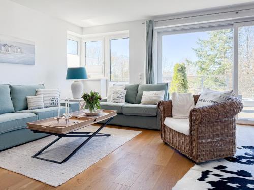 a living room with a couch and chairs and a table at Penthouse am Hafen 2 in Niendorf