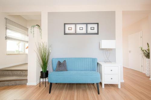 a blue chair in a living room with a plant at Ferienhaus Coordtino in Putbus