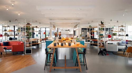 a room with a table and chairs and shelves at Zoku Amsterdam in Amsterdam
