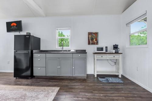 a kitchen with a black refrigerator and a sink at Tiny House on the Hill in New Braunfels