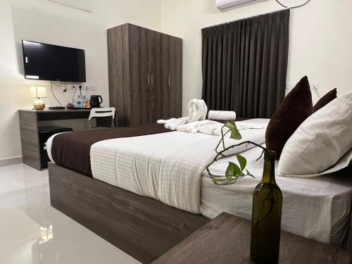 a bedroom with a bed with a bottle of wine at Hotel I Live Inn in Chennai