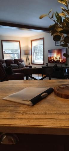 a living room with a table with a fireplace at Le Iris in Saint-Alexis-des-Monts