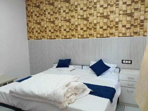 a bedroom with a large bed with blue pillows at Mangaldeep Resort and Garden in Bābai