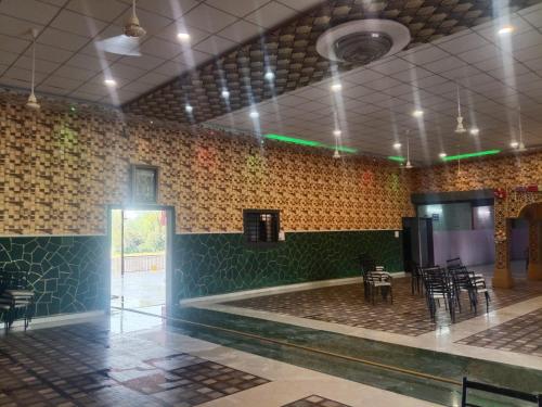 a room with tables and chairs in a building at Mangaldeep Resort and Garden in Bābai