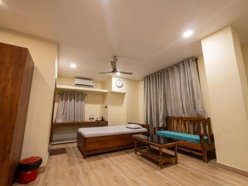 a bedroom with a bed and a couch and a table at M D Guest House in Guwahati