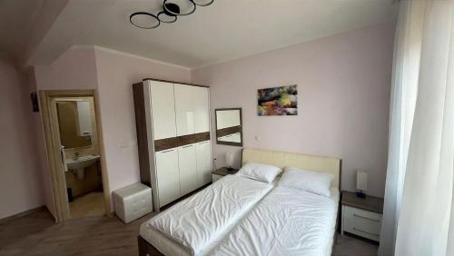 a bedroom with a white bed and a sink at Bella Costa Lux in Dobra Voda