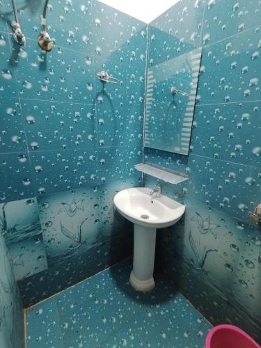 a blue bathroom with a sink and a mirror at M D Guest House in Guwahati