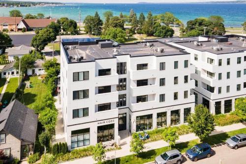 an aerial view of a white building with cars parked outside at 1 Block to Beach | Bikes, Wellness & More in Traverse City