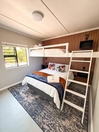 a bedroom with a bunk bed with a ladder at Arc On Ray 31 in Britannia Bay