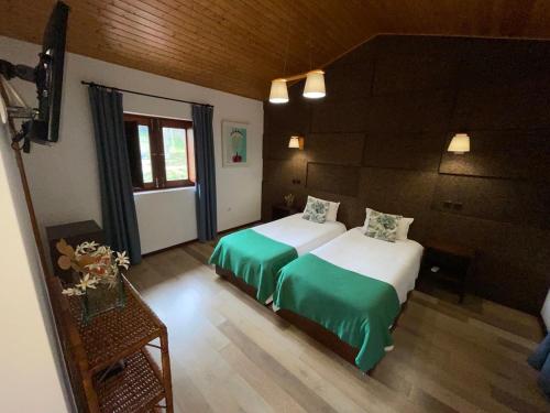 a hotel room with two beds and a window at Rilhadas Casas de Campo in Fafe