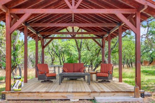 a wooden gazebo with two chairs and a table at Three Sisters - Casita 2 in Wimberley