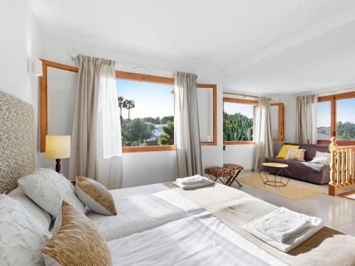 a white bedroom with a large bed and a couch at Casa del Capitán in Santa Ponsa