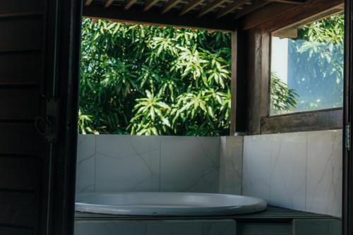 a bathroom with a window and a bath tub at Pipa Panorama Flats&Apartamentos in Pipa