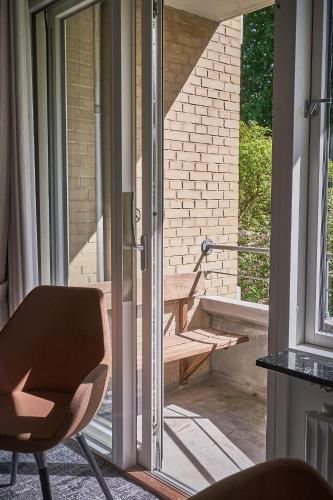 a chair sitting in front of a sliding glass door at Gl Skovridergaard in Silkeborg