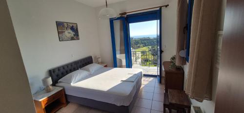 a bedroom with a bed and a large window at Villa Avra - Apartment Hydra in Asgourou